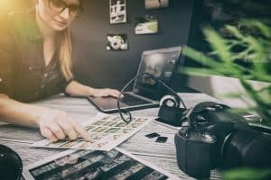 Mujer editando fotografías con cámara profesional